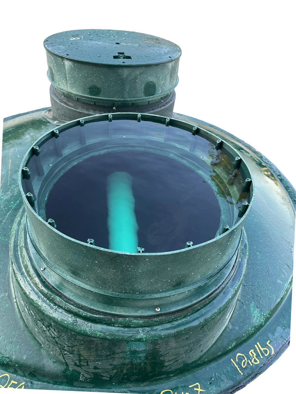 A tank filled with water during compliance testing, lid open and riser exposed